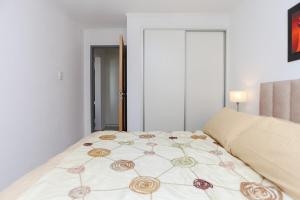 a bedroom with a large bed with a floral bedspread at Departamento a estrenar centro-sur Santa Fe - Urquiza II in Santa Fe