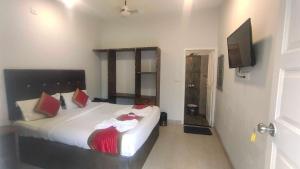 a bedroom with a bed and a flat screen tv at Collection O Titos Lane Baga Formerly Hotel Victoria in Baga