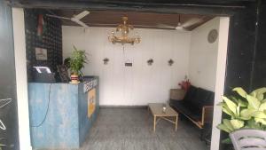 a living room with a couch and a chandelier at Collection O Titos Lane Baga Formerly Hotel Victoria in Baga