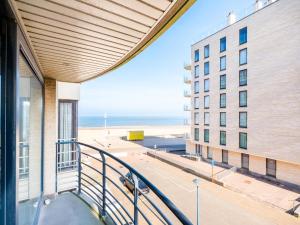 a balcony of a building with a view of the beach at Guernsey tweede in Sint-Idesbald