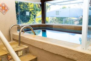 a swimming pool in a building with a window at Pousada Reserva Penedo in Penedo