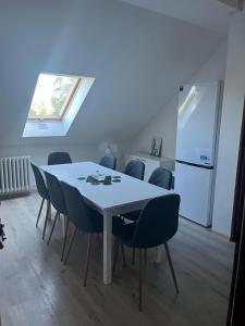 a dining room table with chairs and a refrigerator at Pokoje RELAX in Rybniště