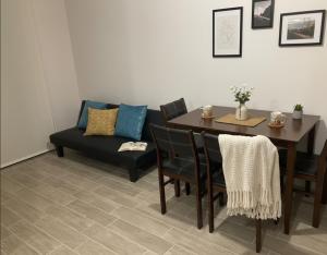a dining room with a table and a couch at Centro I Costanera I Con Estacionamiento I 2Habs in Puerto Montt