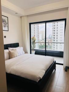 a bedroom with a large bed with a large window at Raydil Homes in Nairobi