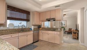 a kitchen with white cabinets and a sink and a window at Indigo West 1404 in Perdido Key