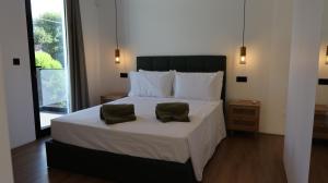 1 dormitorio con 1 cama con 2 almohadas verdes en Plátano Guest House, en Ribeira Chã