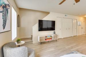 un salon avec une télévision à écran plat sur un mur dans l'établissement 2 Mi to UF Campus Modern Condo with Pool Access!, à West Hills