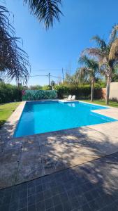 a blue swimming pool with trees in the background at Puntacho in Funes