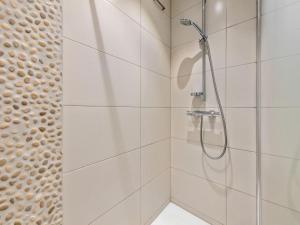 Un baño con ducha con azulejos blancos. en Azcona Twee, en Galopen 8 fotos más