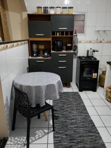 a kitchen with a table with a white table cloth on it at Casa com 1 cama de casal e 1 cama de solteiro in Serra