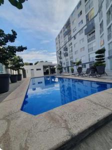 a swimming pool in front of a building at Centrally located apartment with AC, parking and pool in Guadalajara