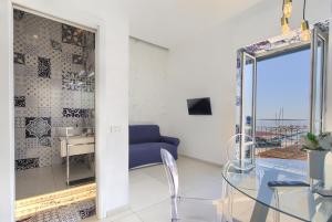 a living room with a glass table and a blue couch at Relais Luxury Retreat - Seafront Apartments in Salerno