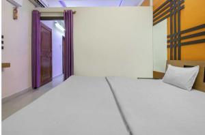 a room with two beds and a door at Hotel O Three Lamps Junction Vizianagaram in Vizianagram City +8 photos