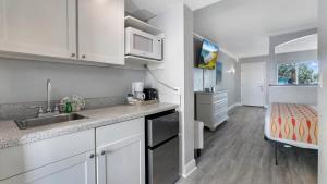 a kitchen with a sink and a bed in a room at Pelican Pointe Clearwater Beach Hotel in Clearwater Beach