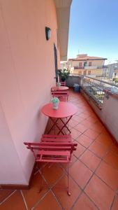 a red table and two benches on a balcony at The Loft E&E Lofty Rooms in Empoli
