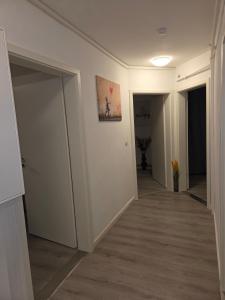 a hallway with white walls and an open door at Wohlfühl-Insel in Ludwigshafen am Rhein