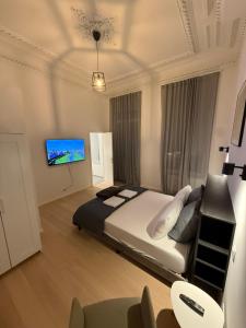 a bedroom with a large bed and a flat screen tv at The Gallery Saint-Gilles in Brussels