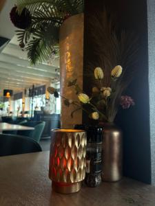 a table with a vase with flowers in it at Hotel aan de Linge in Kedichem