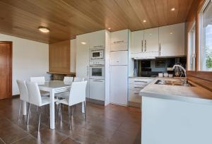 a kitchen with white appliances and a table and chairs at Ca la Lola in Tortellá