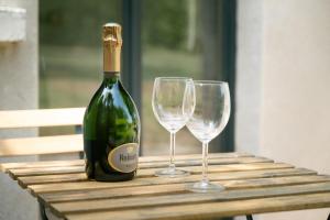 a bottle of wine and two wine glasses on a table at Terrasse, Nature Fontainebleau in Fontaine-le-Port