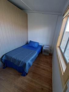 a small bed in a small room with a window at Central House in Punta Arenas