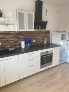 a kitchen with white cabinets and a black counter top at Ferienwohnung für Monteure in Erlenbach am Main +5 photos