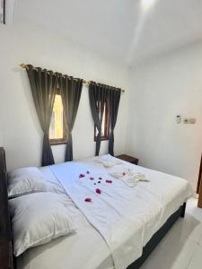 a bedroom with a white bed with red roses on it at Gina's Reading Homestay 