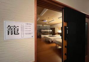 a room with two beds and a sign on the wall at 鈴籠城 全室貸切 in Nagahama