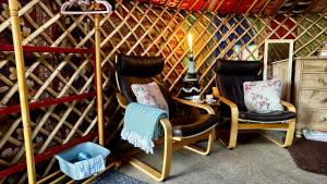 two chairs in a room with a wall of wine bottles at Brambles Glamping in Bengeworth