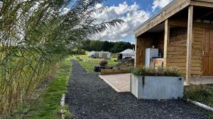 a house with a path next to a building with a yard at Brambles Glamping in Bengeworth