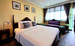 ein Schlafzimmer mit einem großen weißen Bett und einem Stuhl in der Unterkunft Focal Local Bed & Breakfast in Bangkok