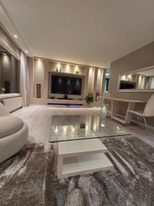 a living room with a tv and a glass coffee table at Apartment, everything close in Hamar