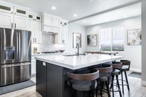 a kitchen with white cabinets and a large island with bar stools at Great views luxe gym fireplace deck sleeps 8 in Cranmer