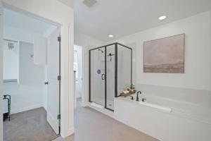 Un baño blanco con ducha y lavabo. en Scandinavian-Inspired 3br2.5ba sleeps 8 stylish, en Parkview Trailer Court 45 fotos más