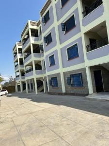 un gran edificio de apartamentos blanco con muchas ventanas en Shukrey palace 4, en Naivasha