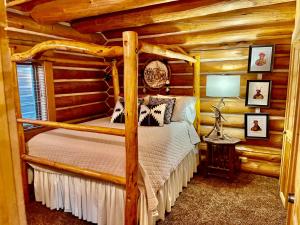 a bedroom with a four poster bed in a log cabin at Sundance cabincasita sleeps 18 hottub firepits in Sundance