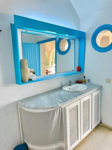 a bathroom with a sink and a blue mirror at Peaceful Haven, Villa Private Rooms, Absolute Quiet in Bin Rhilouf