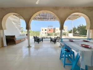 a large room with arches and a table and chairs at Peaceful Haven, Villa Private Rooms, Absolute Quiet in Bin Rhilouf
