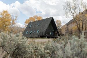 una casa con un techo negro en un campo en A-Frame Haus Heber views romantic firepit cute, en Timber Lakes