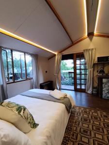 Un dormitorio con dos camas en una habitación con ventanas. en Koinonia Bush Lodge, en Hartbeespoort