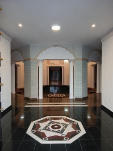 Habitación grande con suelo de baldosa y alfombra. en De Sultana Villa, en Mascate