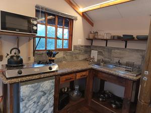 a kitchen with a stove and a sink in it at Koinonia Bush Lodge in Hartbeespoort