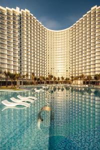 un grand bâtiment hôtelier avec une grande piscine dans l'établissement Resort The Wins Arena Cam Ranh, à Cam Ranh