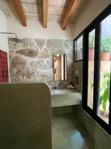 a bathroom with a sink and a stone wall at El Diablo y La Luna B&B in Oaxaca City