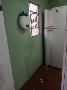 a kitchen with a white refrigerator and a window at Samsarah House in Sao Paulo