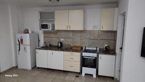 una cucina con mobili bianchi e un frigorifero bianco di Departamento Temporario con Cochera a Corrientes