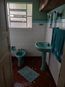 a bathroom with a green sink and a toilet at Samsarah House in Sao Paulo +8 photos