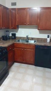 Addison HeightsにあるArlington Stay with Easy Metro and Business Accessの木製のキャビネットとシンクを備えたキッチン