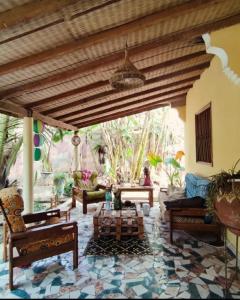 una sala de estar con muebles y techo de madera. en Mango House, en Saly Portudal
