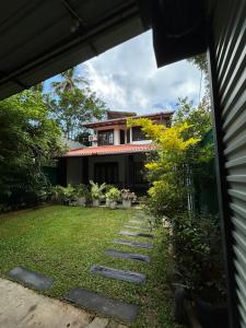 a garden with stepping stones in front of a house at Villa Petria in Galle